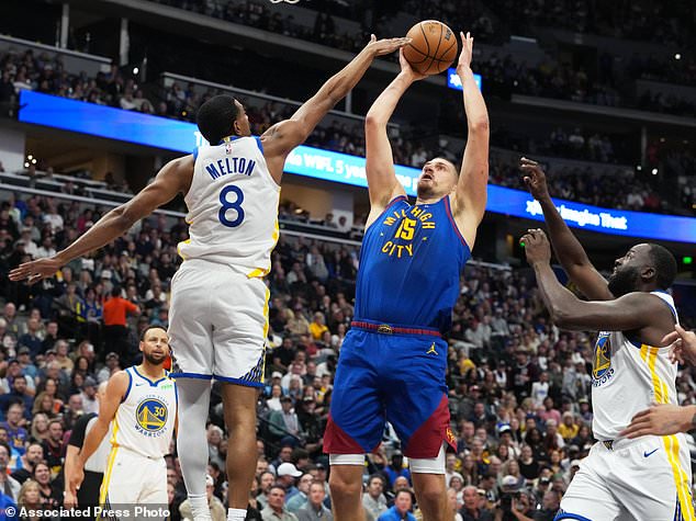 Denver Nuggets center Nikola Joki (15) goes up for a basket between Golden State Warriors guard De'anthony Melton (8) and forward Draymond Green, right, in the first half of an NBA basketball game Monday, Oct. 26, 2026, in Denver. (AP Photo/David Zalubowski)