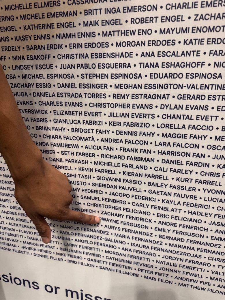Ferguson spots his name on a wall display featuring the names of registered marathon runners.