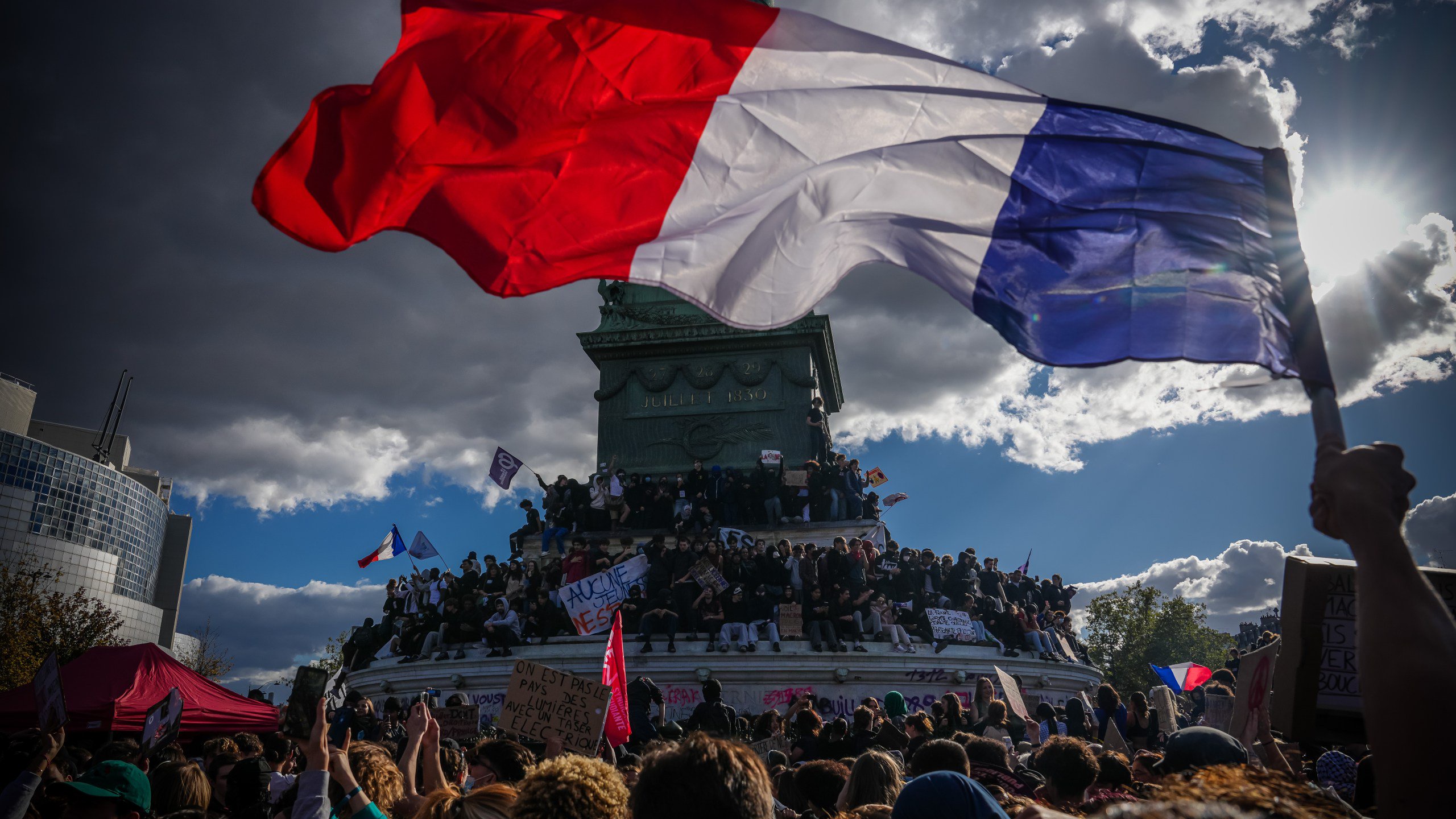 A person holds a French national flag during a protest against under-resourced schools in Paris, Thursday, Oct. 8, 2026. (AP Photo/Aurelien Morissard)