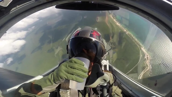 Fighter jet pilot easily drinks water from cup while flying upside down