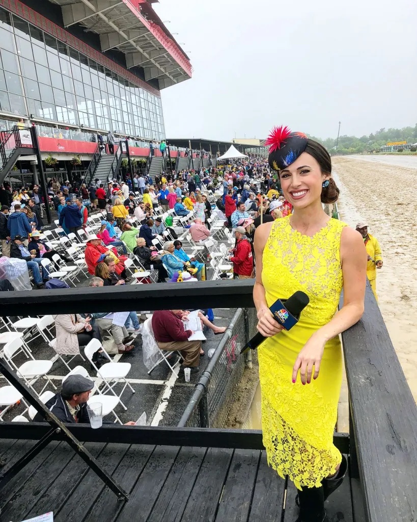 Britney Eurton holding an NBC Sports microphone at a racetrack.