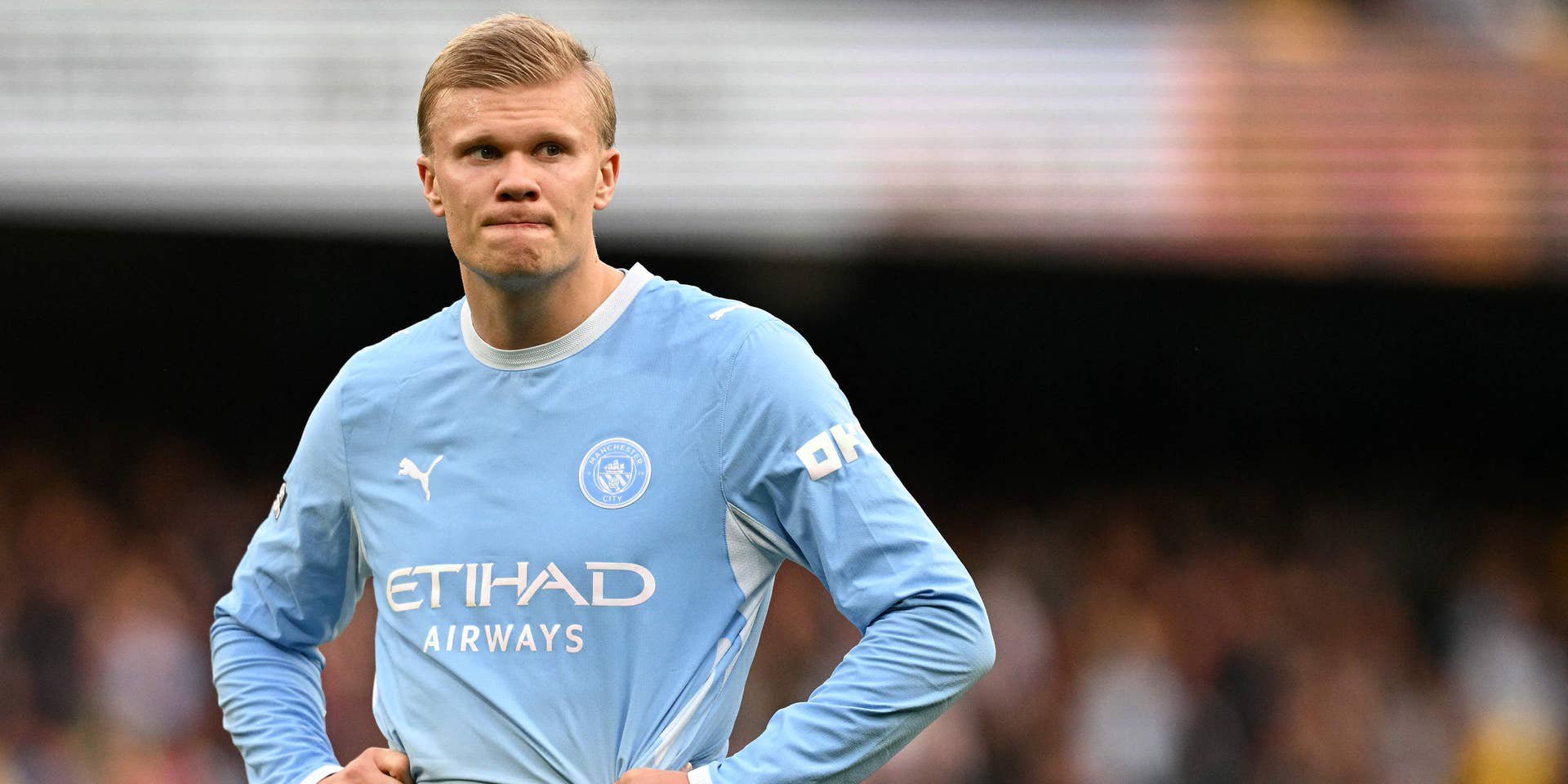 Ein Fußballspieler von Manchester City steht enttäuscht auf dem Spielfeld mit den Händen in der Hüfte.