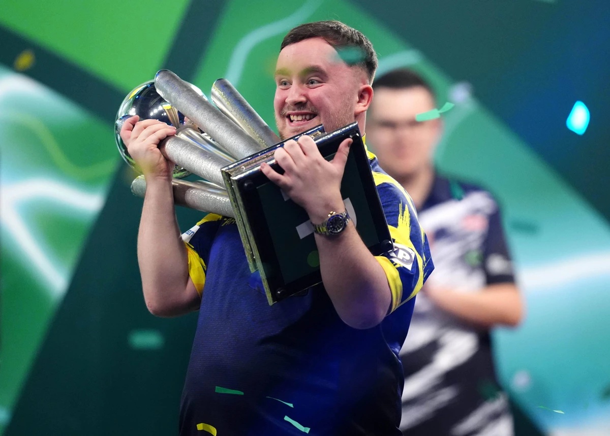 Luke Littler celebrates with the Sid Waddell trophy after victory against Gian van Veen after the final of the Paddy Power World Darts Championship at the Alexandra Palace in London, Saturday, Jan. 3, ...