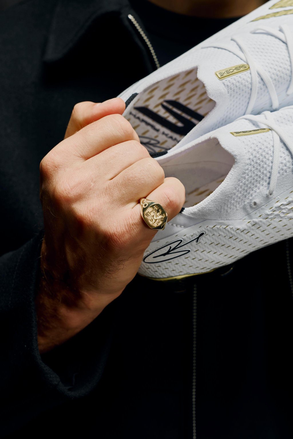 Harry Kane holds a pair of custom Skechers football boots crafted in 24-carat gold leaf.