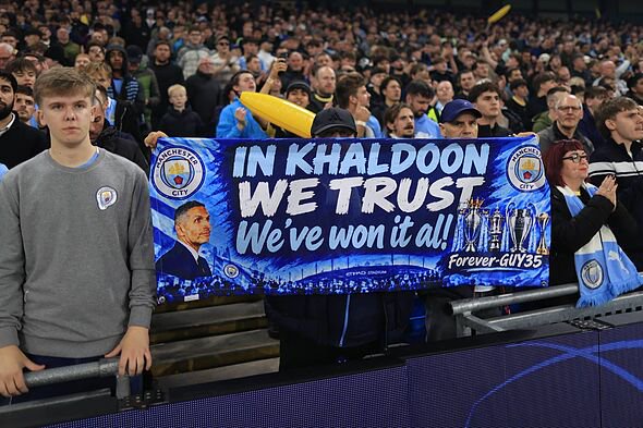A Manchester City fan holds up a banner in support of the club chairman Khaldoon Al Mubarak during the UEFA Champions League 202