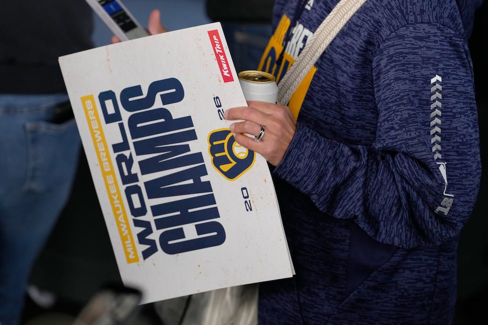 A fan holds a sign as they arrive for a rally during the baseball team's World Series parade,...