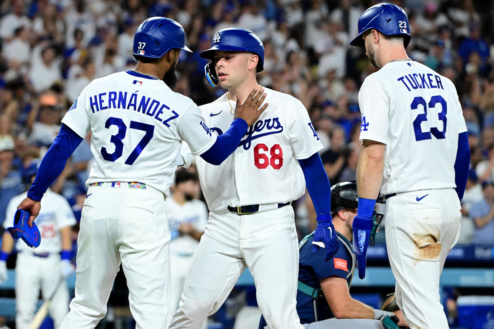 Los Angeles Dodgers players Teoscar Hernandez, Dalton Rushing, and Kyle Tucker celebrate a home run against the Seattle Mariners.