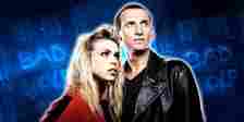 Rose Tyler and The Ninth Doctor in front of Doctor Who's Bad Wolf Reference