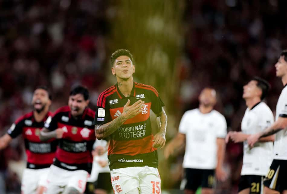 Carrascal comemora gol em partida de futebol, cercado por companheiros; torcida ao fundo.