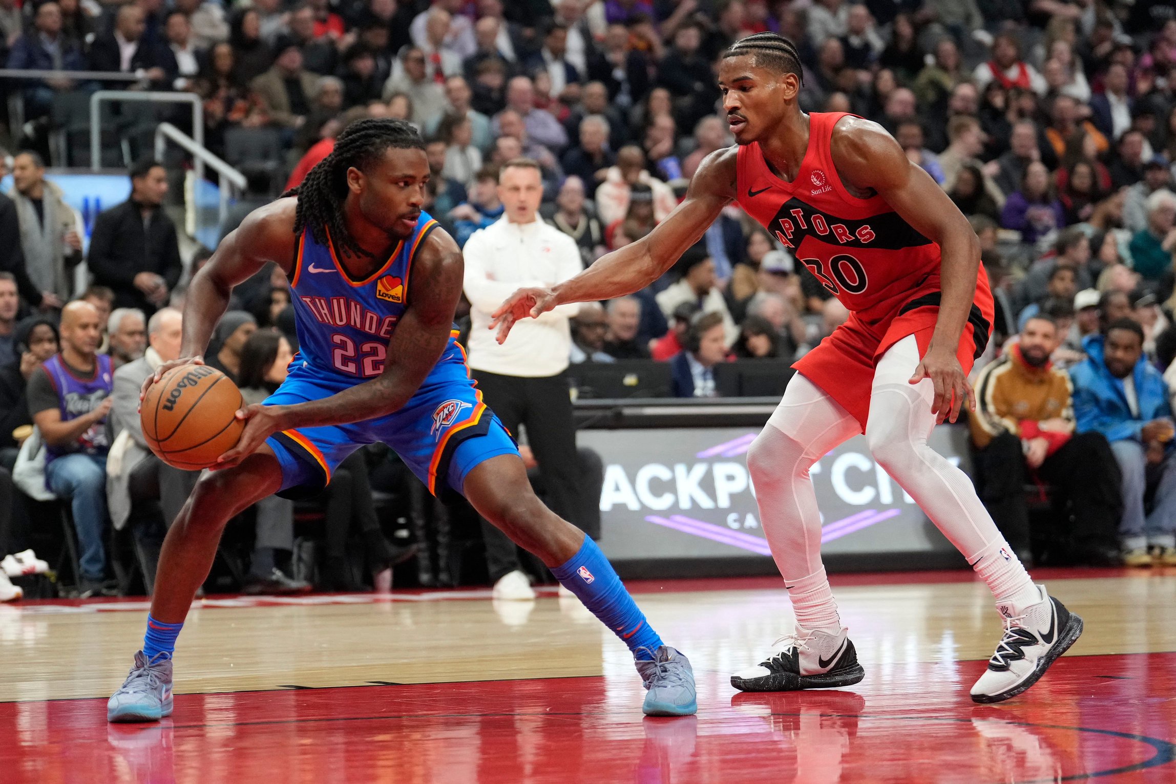 Dec 5, 2024; Toronto, Ontario, CAN; Oklahoma City Thunder guard Cason Wallace (22) controls the ball against Toronto Raptors guard Ochai Agbaji (30) during the first half at Scotiabank Arena. Mandatory Credit: John E. Sokolowski-Imagn Images