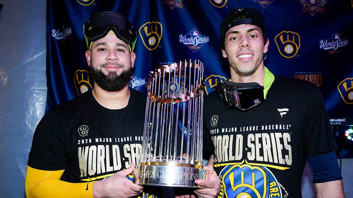 Gary Sánchez and Christian Yelich pose with the Commissioner's Trophy.