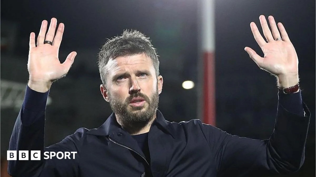Manchester United head coach Michael Carrick holds his hands up to apologise to the away fans in Como