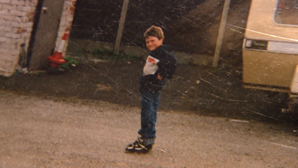 Childhood photo of Tyson Fury standing outdoors with his hands on his hips.