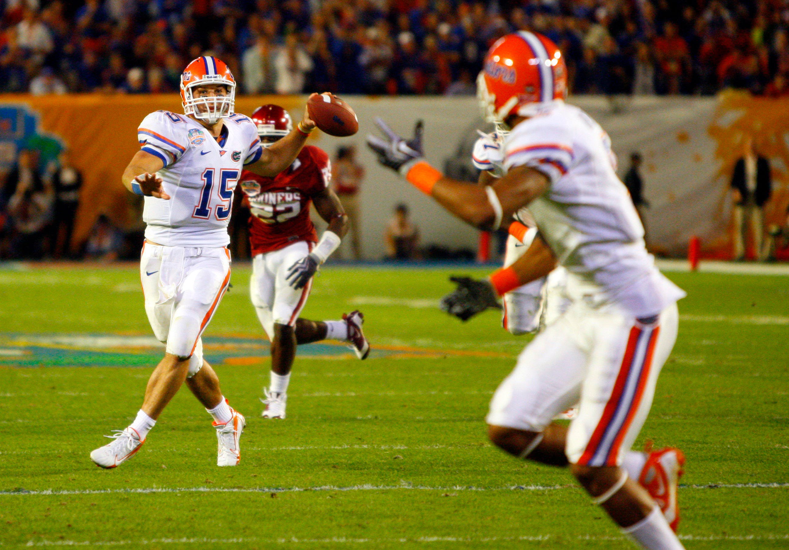 Jan 8, 2008; Miami, FL, USA; Florida Gators quarterback Tim Tebow (15) throws a pass to wide receiver Louis Murphy (front) for a touchdown during the second quarter of the 2009 BCS Championship Game against the Oklahoma Sooners at Dolphin Stadium. Mandatory Credit: Kim Klement-USA TODAY Sports