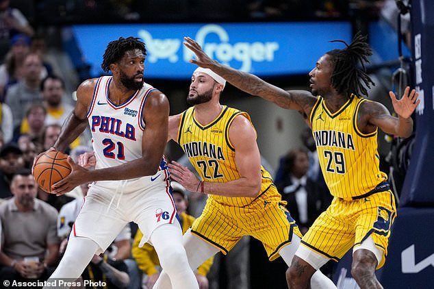 Indiana Pacers guard Quenton Jackson (29) and forward Larry Nance Jr. (22) defend Philadelphia 76ers center Joel Embiid (21) during the first half of an NBA basketball game in Indianapolis, Wednesday, Oct. 28, 2026. (AP Photo/Michael Conroy)