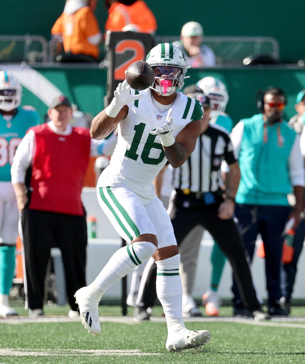 A New York Jets player wearing number 16 catches a pass during a game against the Miami Dolphins at MetLife Stadium.