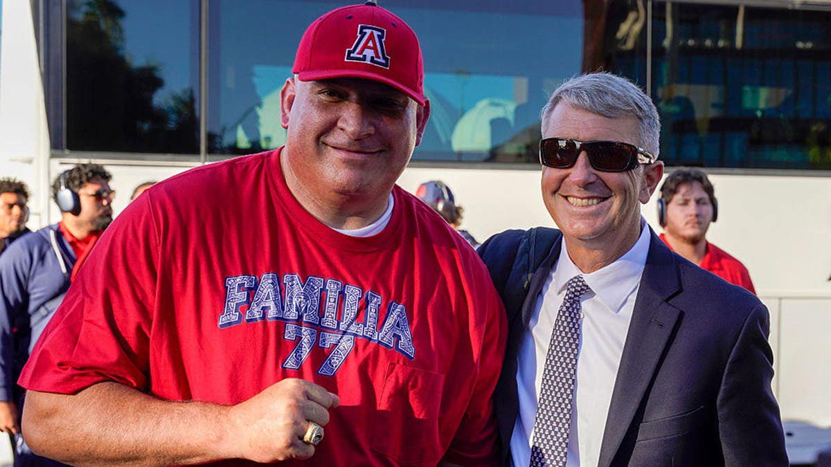 Brent Brennan and Jose Portilla stand together before a college football game.
