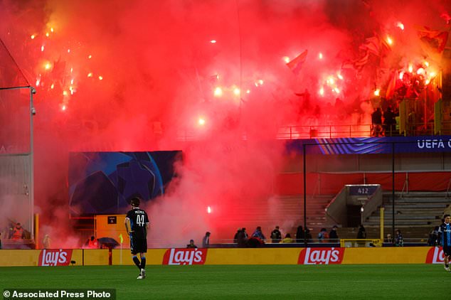 Lens supporters light flares during the Champions League opening phase soccer match between Club Brugge and Lens in Bruges, Belgium, Wednesday, Oct. 21, 2026. (AP Photo/Geert Vanden Wijngaert)