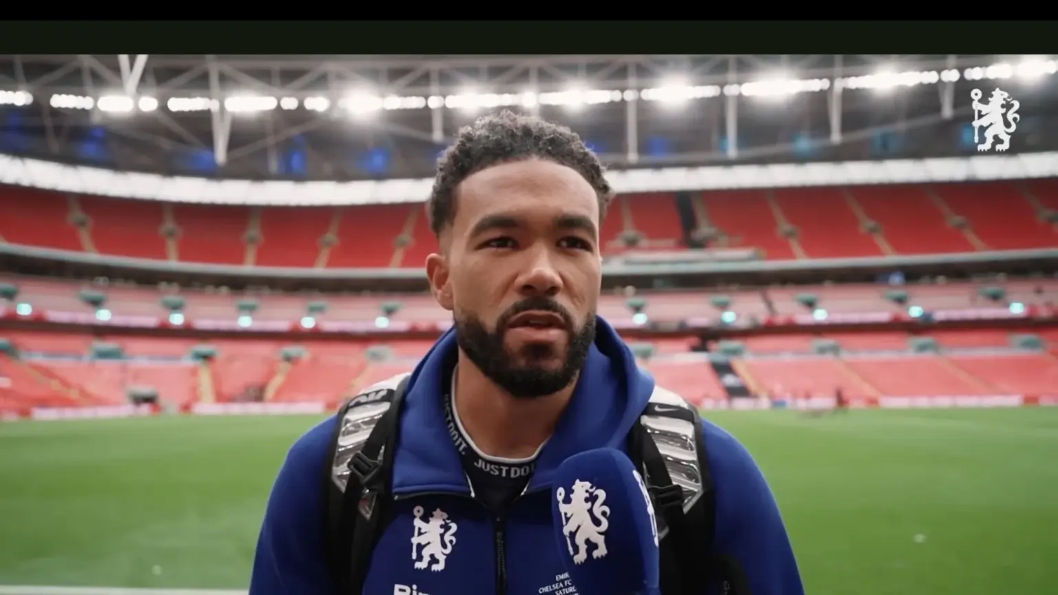 Reece James speaking into a microphone at a stadium.