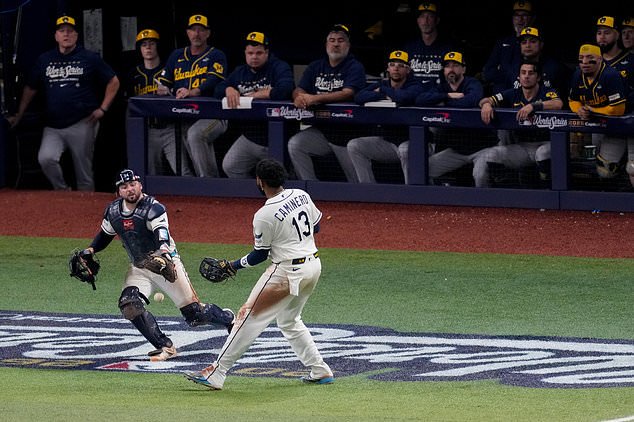 Tampa Bay Rays catcher Liam Hicks (34) and third baseman Junior Caminero (13) can't catch a foul ball hit by Milwaukee Brewers first baseman Jake Bauers during the inning of Game 4 of baseball's World Series, Tuesday, Oct. 27, 2026, in St. Petersburg, Fla., between the Milwaukee Brewers and the Tampa Bay Rays. (AP Photo/Morry Gash)