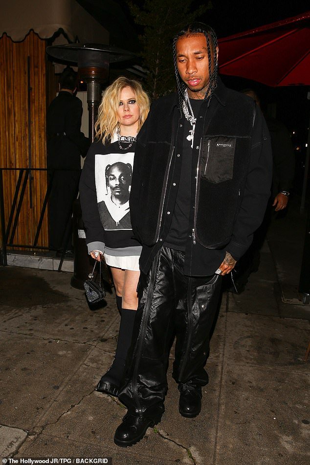 Stylish: She kept the rest of her look lowkey, teaming a Snoop Dogg print jumper with a white shirt dress and chunky platform boots