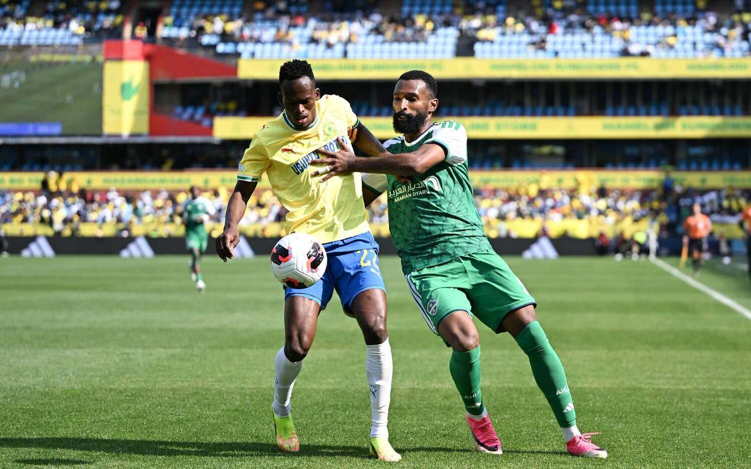Mamelodi Sundowns defender Thabang Matuludi shruggs off the challenge of an Al Ahli player during a FIFA Intercontinental Cup match.