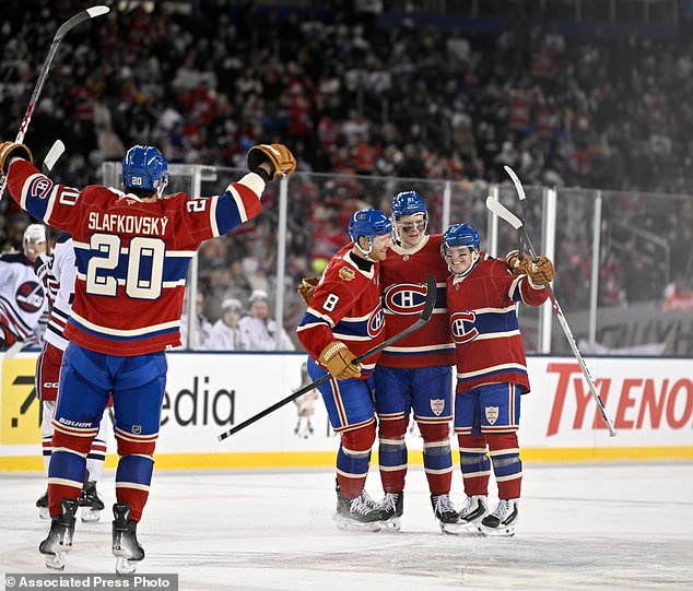 Montreal Canadiens' Kaiden Guhle (21) celebratesafter his goal against the Winnipeg Jets with Mike Matheson (8), Cole Caufield (13) and Juraj Slafkovsky (20) during the second period of the NHL Heritage Classic hockey game in Winnipeg, Manitoba, Sunday, Oct. 25, 2026. (Fred Greenslade/The Canadian Press via AP)