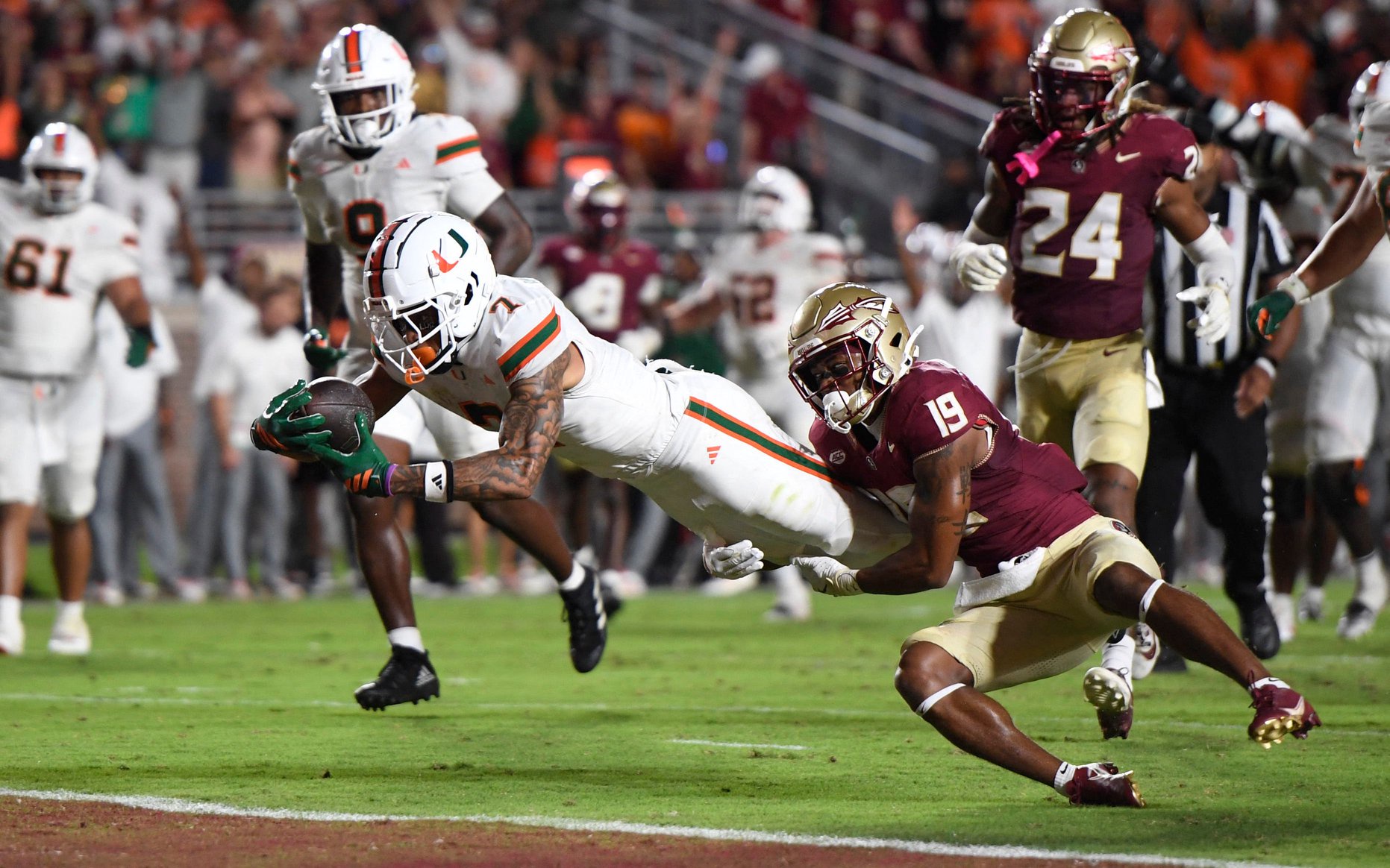 Oct 4, 2025; Tallahassee, Florida, USA; Miami Hurricanes wide receiver CJ Daniels (7) scores a touchdown against Florida State Seminoles defensive back Jerry Wilson (19) during the second half at Doak S. Campbell Stadium. Mandatory Credit: Robert Myers-Imagn Images