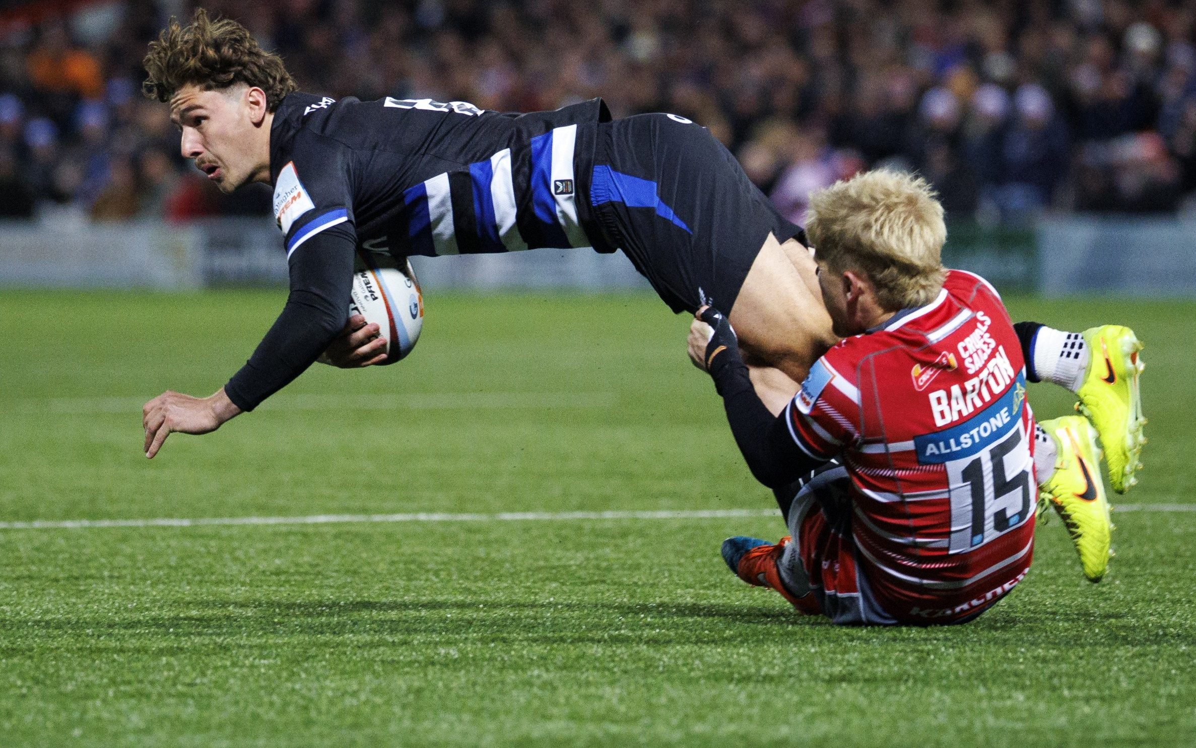 Bath Rugby's Ciaran Donoghue is tackled by Gloucester's George Barton