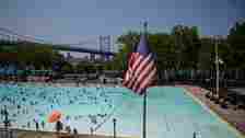 Swimmers and sunbathers use a public pool at Astoria Park in Queens