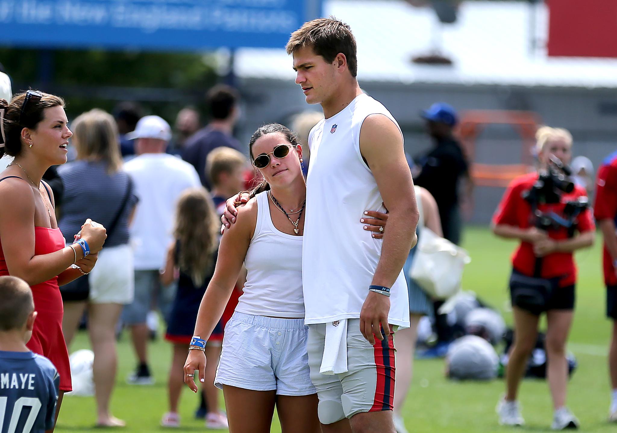 New England Patriots quarterback Drake Maye greets his wife, Ann Michael Maye, after practice.