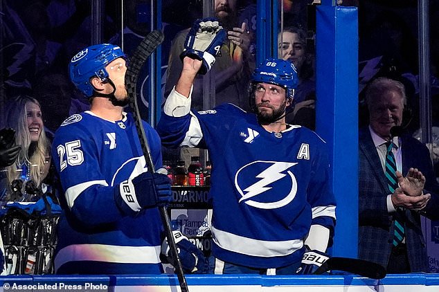 Tampa Bay Lightning right wing Nikita Kucherov, right, waves to the crowd after a video presentation for Kucherov becoming the Lightning's all-time leading scorer during the first period of an NHL hockey game against the Winnipeg Jets Thursday, Oct. 29, 2026, in Tampa, Fla. (AP Photo/Chris O'Meara)