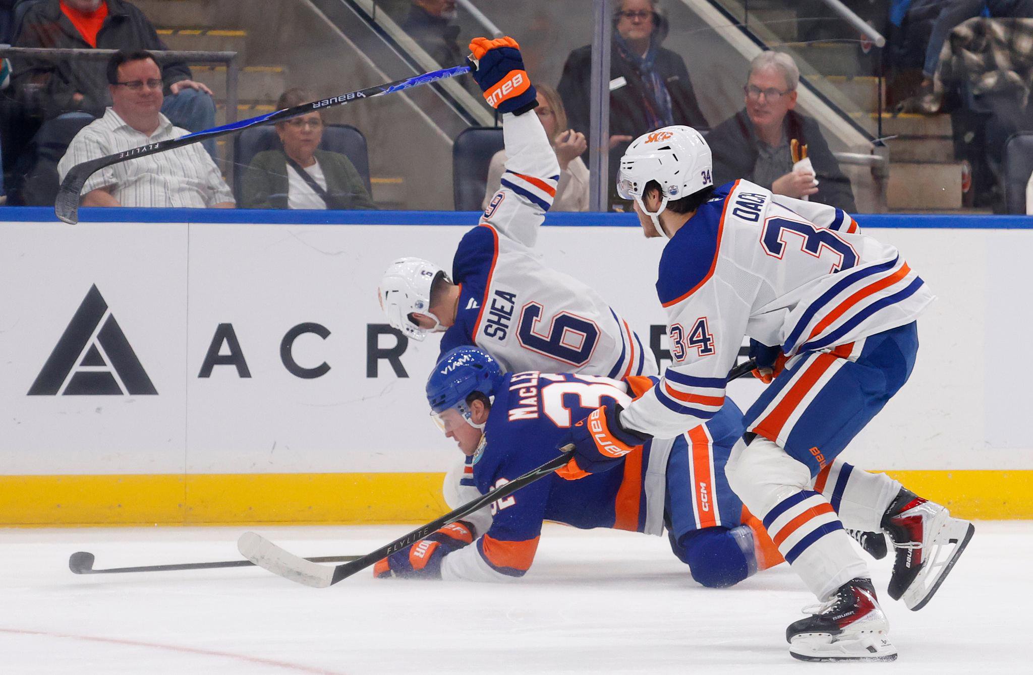 New York Islanders center Kyle MacLean checks Edmonton Oilers defenseman Ryan Shea.