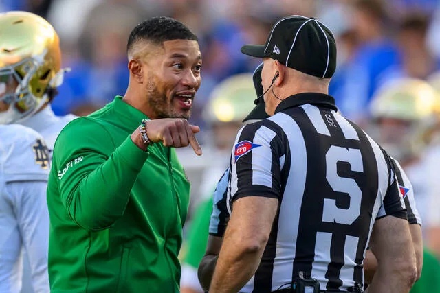 <p>Notre Dame head coach Marcus Freeman, left, has a discussion with sideline judge Chris Junjulas, right, during the first half of an NCAA college football game against BYU, Saturday, Oct. 17, 2026, in Provo, Utah.</p>
                                 <p>Tyler Tate | AP Photo</p>