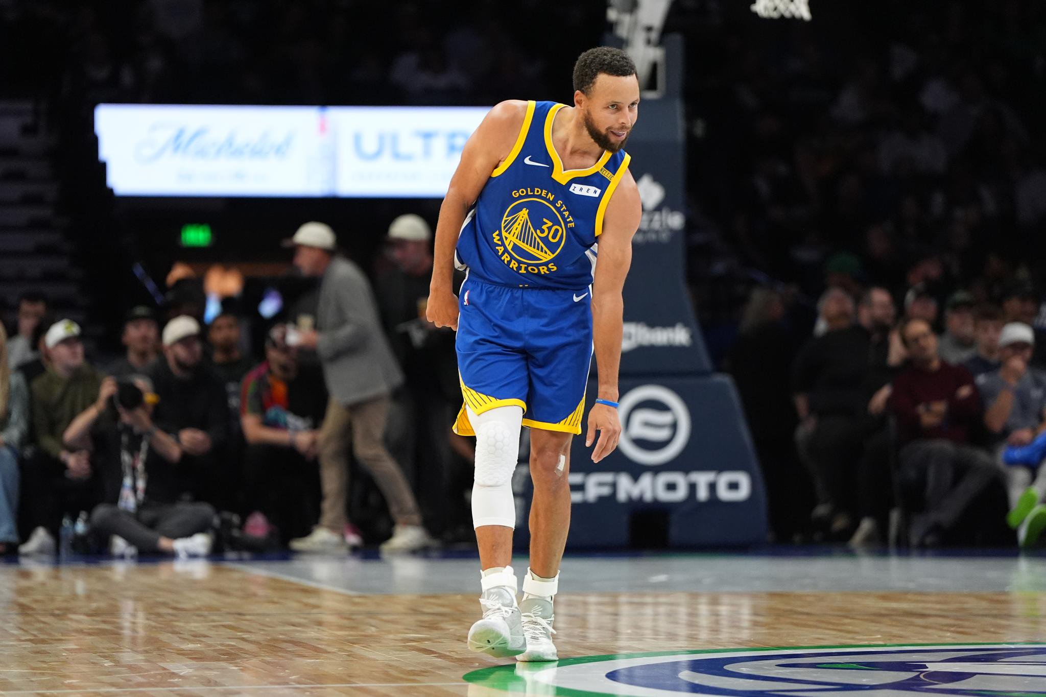 Stephen Curry in a Golden State Warriors uniform on the basketball court.