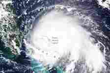 Satellite image of a hurricane over The Bahamas, marked on the map, next to  Florida.
