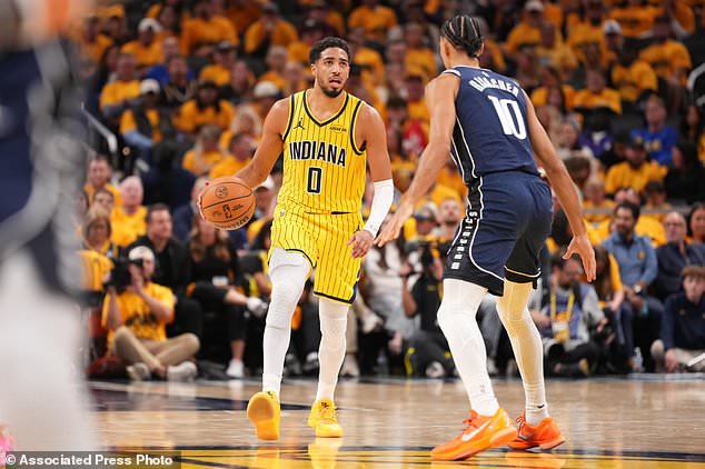 Indiana Pacers guard Tyrese Haliburton (0) brings the ball up in front of Dallas Mavericks forward Zaccharie Risacher (10) during the first half of an NBA basketball game in Indianapolis, Friday, Oct. 23, 2026. (AP Photo/AJ Mast)