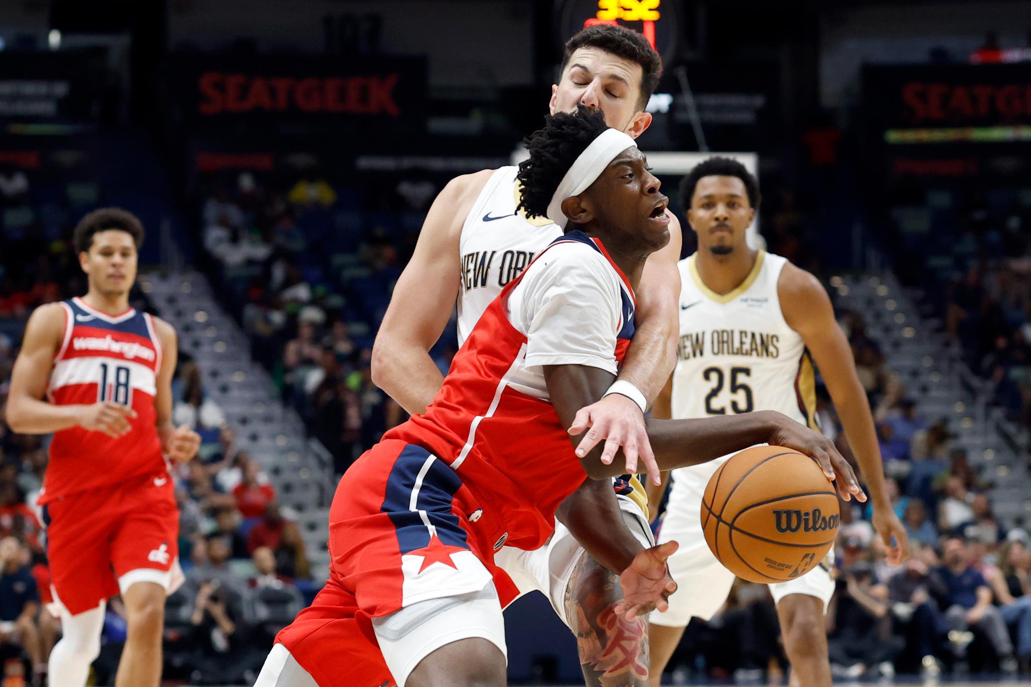 AJ Dybantsa of the Washington Wizards is fouled by Karlo Matkovic of the New Orleans Pelicans during a game.