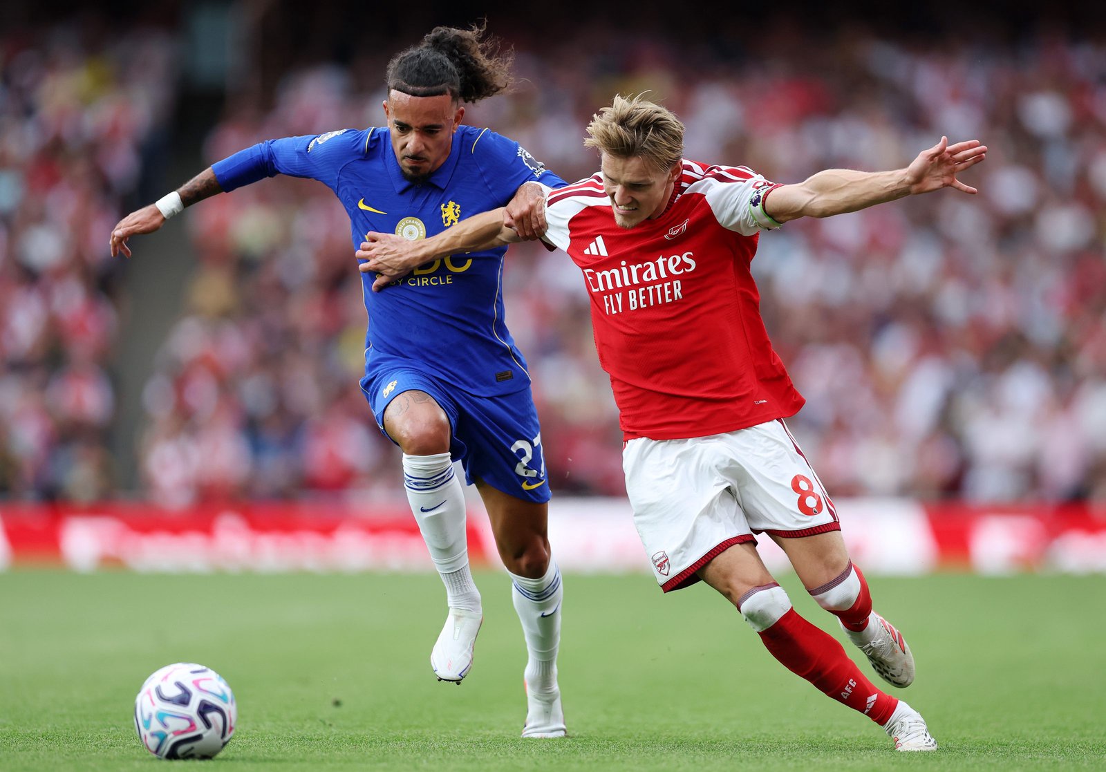 Martin Odegaard of Arsenal is challenged by Malo Gusto of Chelsea