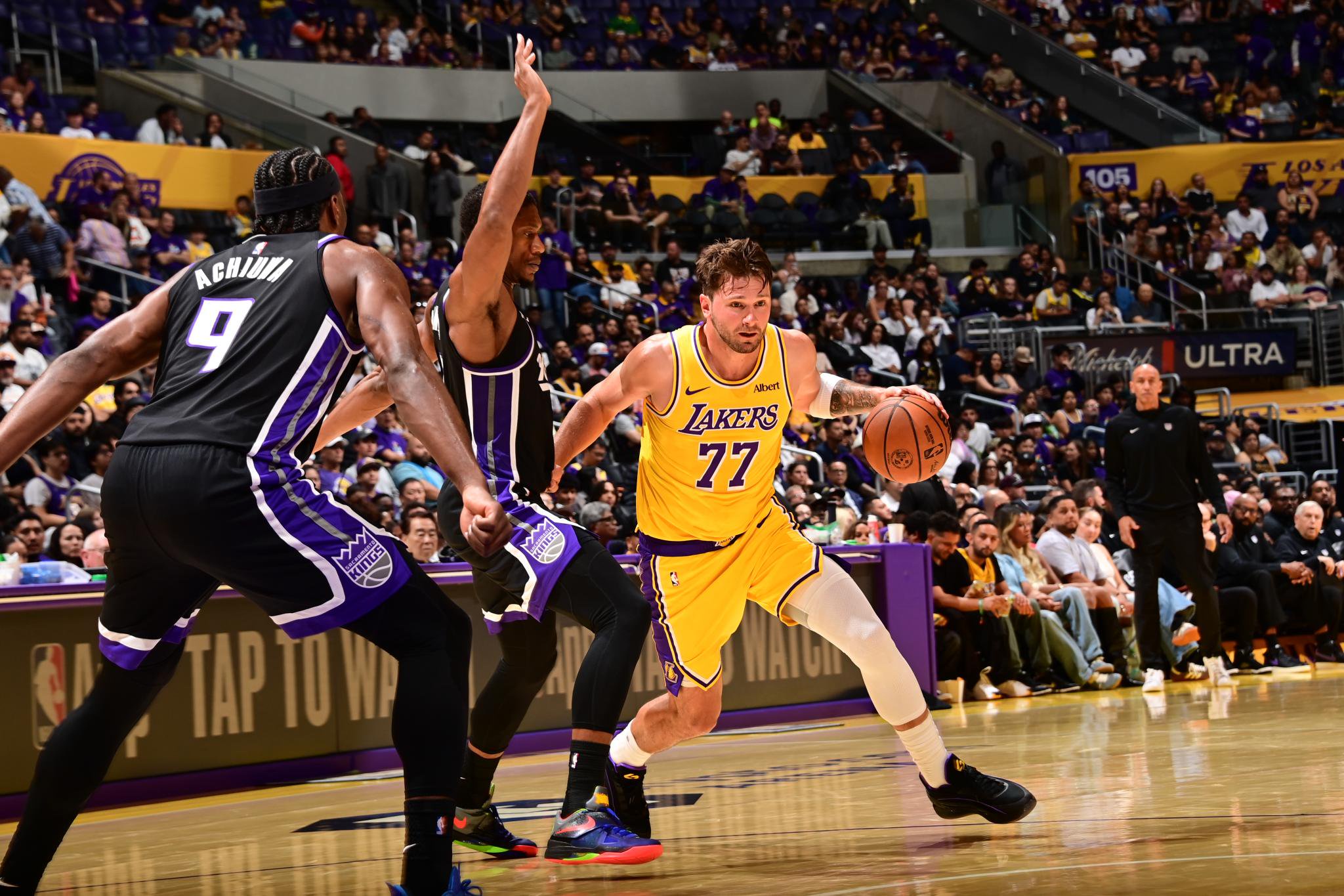 Luka Doncic of the Los Angeles Lakers dribbles the ball past Sacramento Kings defenders.