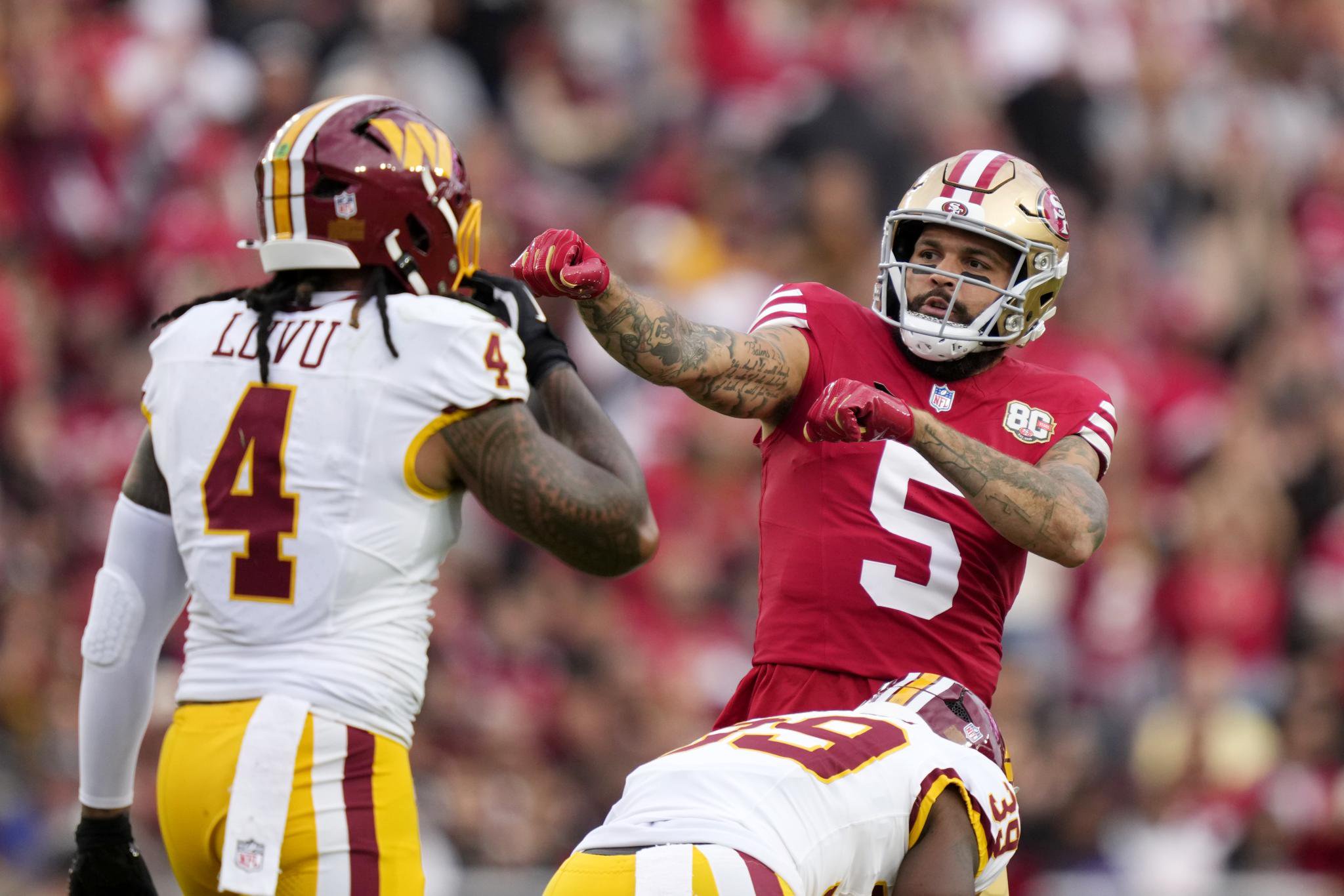 San Francisco 49ers player gestures during a game against the Washington Commanders.