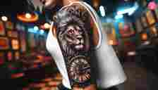 A half-sleeve lion clock tattoo covering the upper arm till the elbows