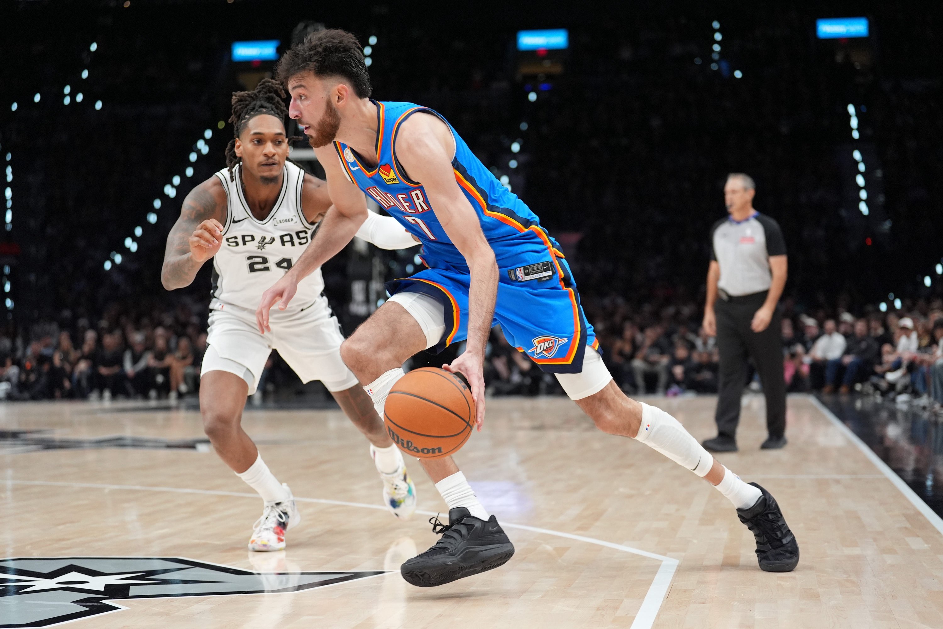 Oct 20, 2026; San Antonio, Texas, USA;  Oklahoma City Thunder center Chet Holmgren (7) dribbles against San Antonio Spurs guard Devin Vassell (24) in the first half at Frost Bank Center.  Mandatory Credit: Daniel Dunn-Imagn Images