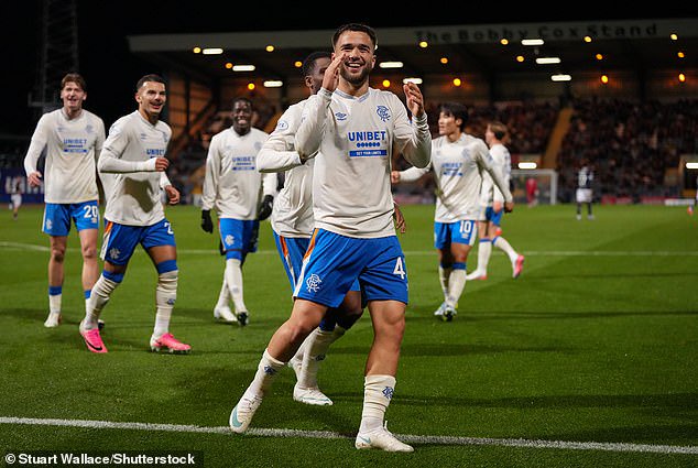Raskin prepares to celebrate with his team-mates after scoring in Premiership clash at Dens