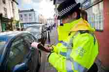 Police officer writes out ticker for driver in car