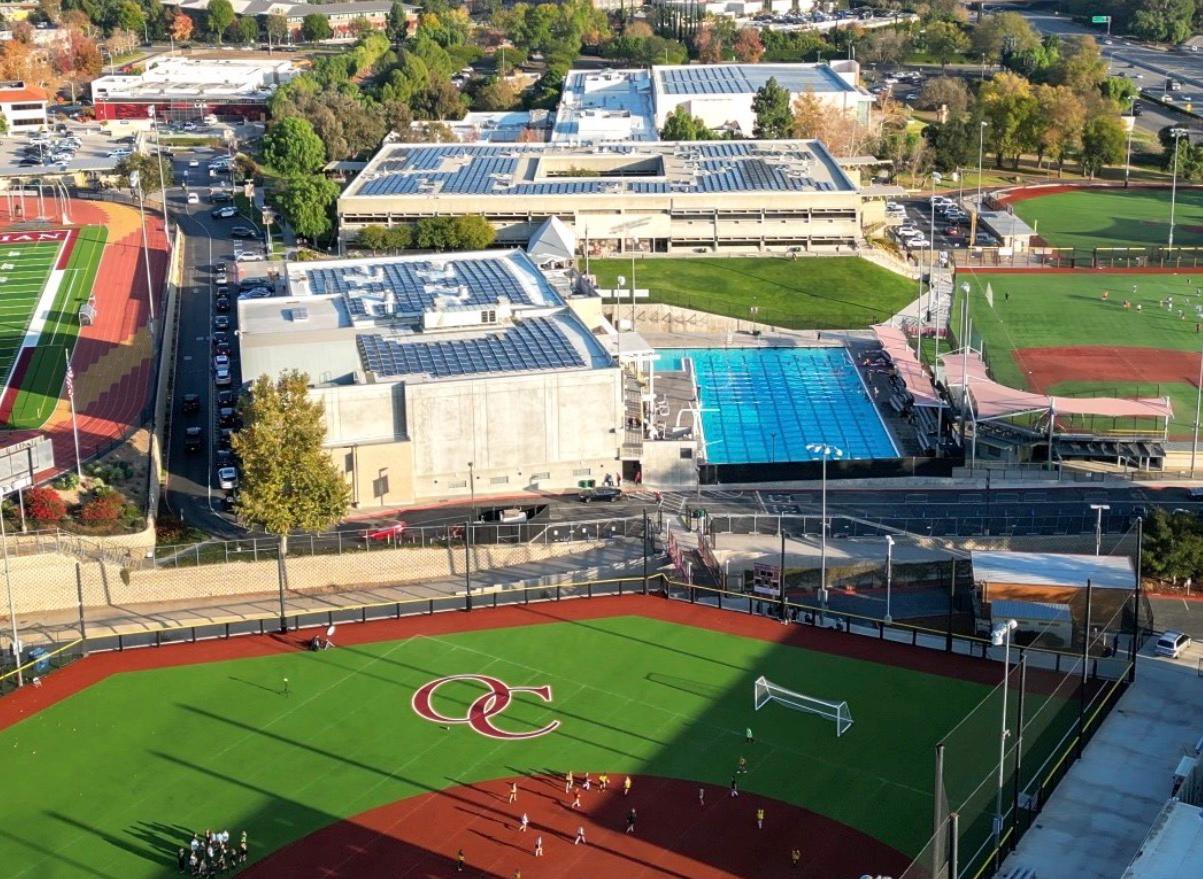 An aerial view of the Oaks Christian School campus, featuring academic buildings, a swimming pool, and athletic fields.