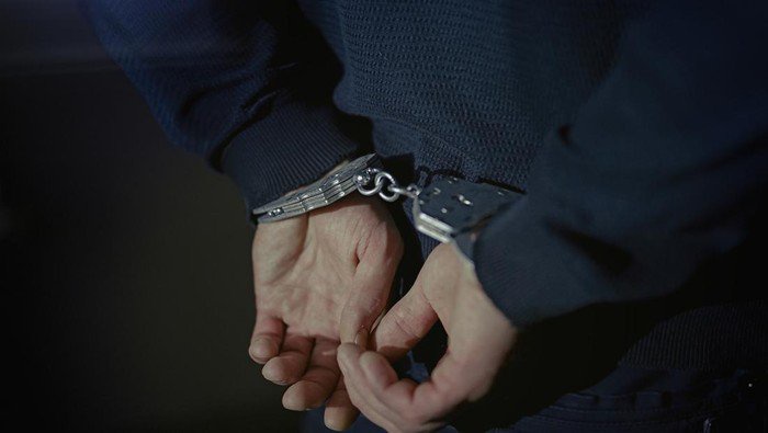 Arrested man handcuffed hands at the back