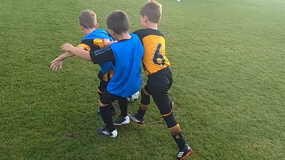 Three children playing 3v3 football 