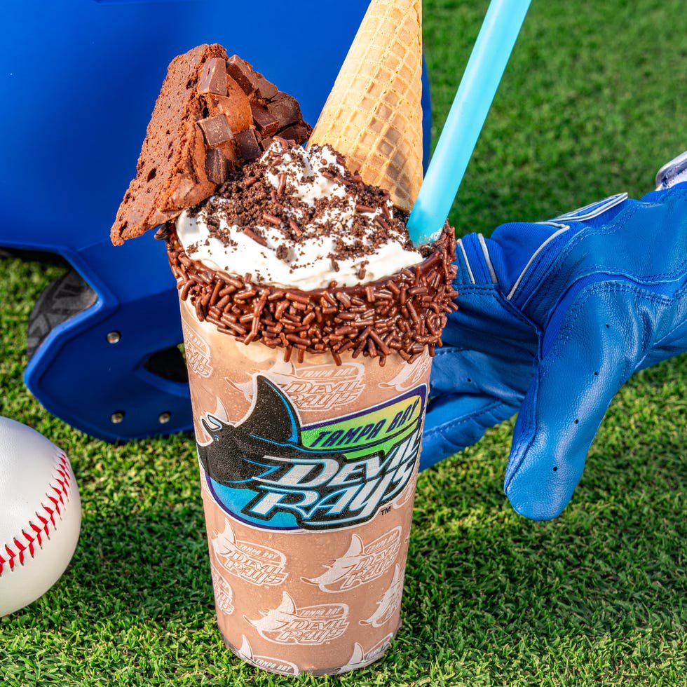 A dessert drink resembling a shake with toppings, positioned near baseball equipment.