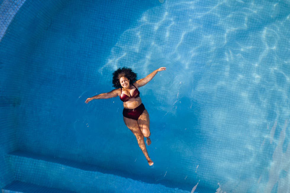top view of woman relaxing in swimming poll